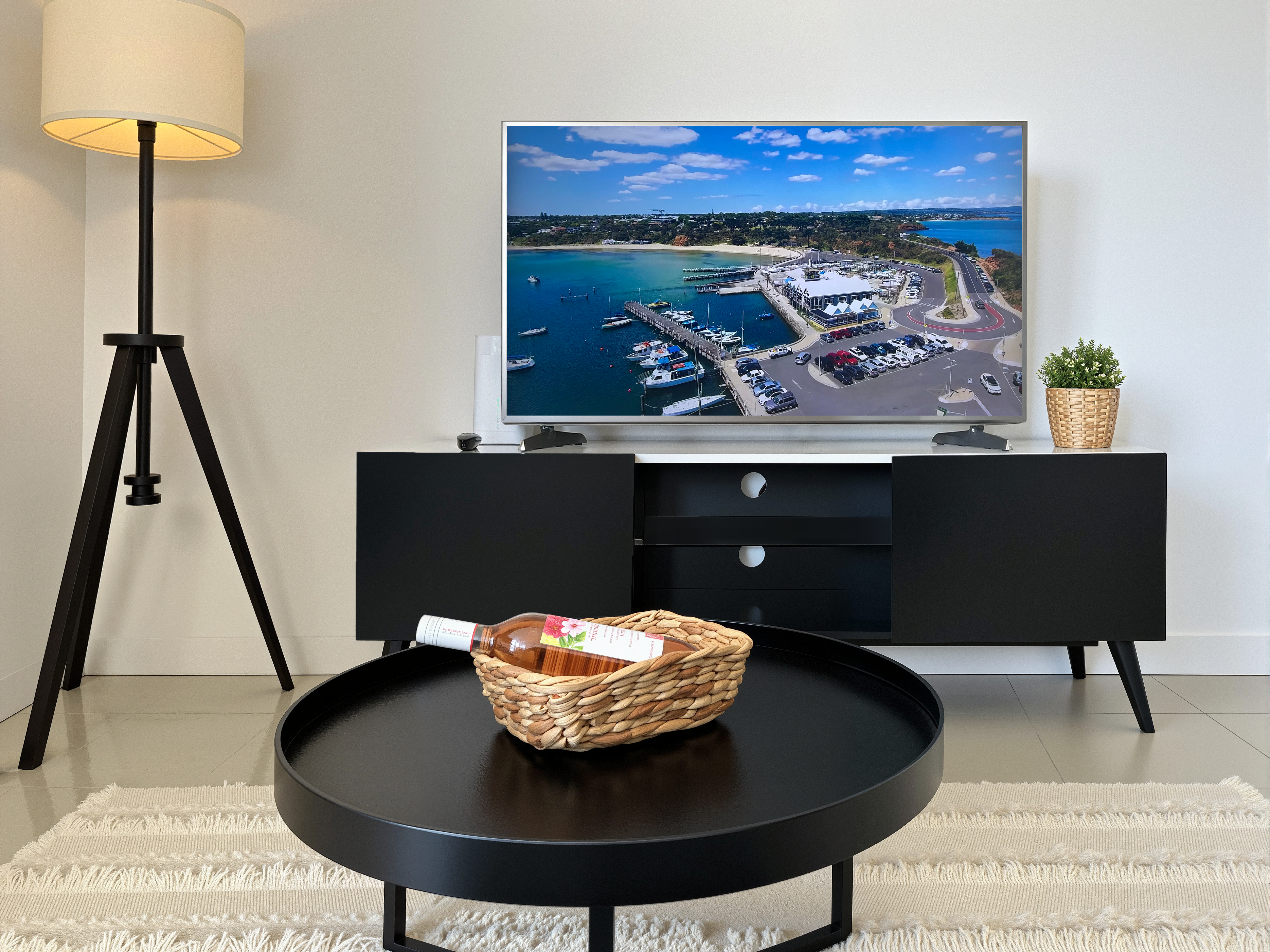 Living room with TV showing a coastal marina view